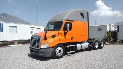 Tractocamión Freightliner Cascadia con cabina en wrap naranja y techo gris, vista frontal