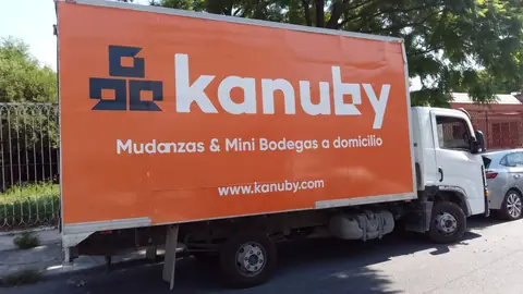 Camión con caja forrada en naranja con servicios de mudanza a domicilio