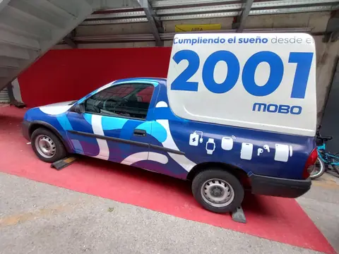 Chevrolet pickup con wrap azul de figuras y camper rotulado, vista lateral