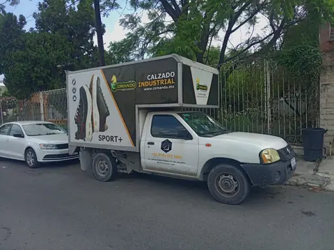 Pickup Nissan con caja rotulada de línea de calzado industrial deportivo