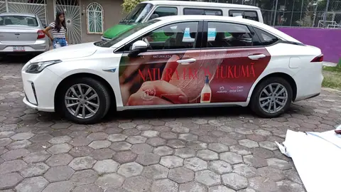 Sedán blanco con wrap parcial en ambas puertas, vista lateral