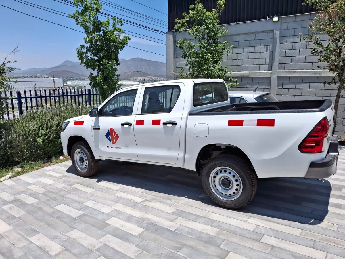 Pick-up corporativa con franjas reflejantes rojas y blancas en los costados